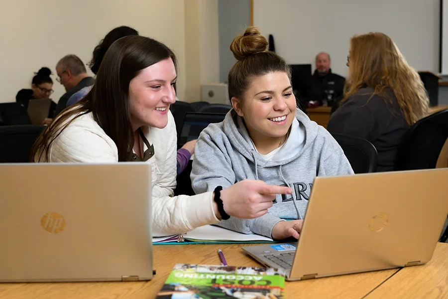 Two accounting students study together in a lecture hall