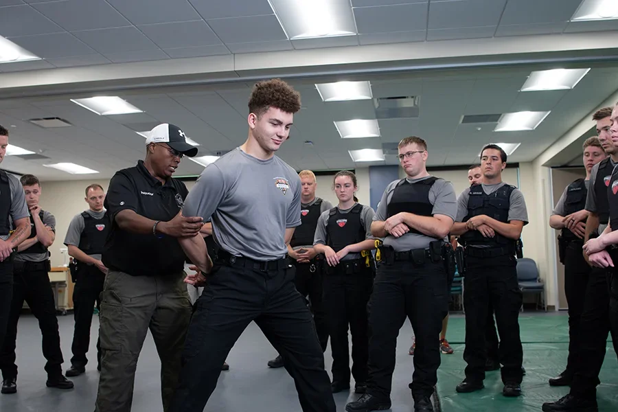 Students practice self-defense moves in a classroom.