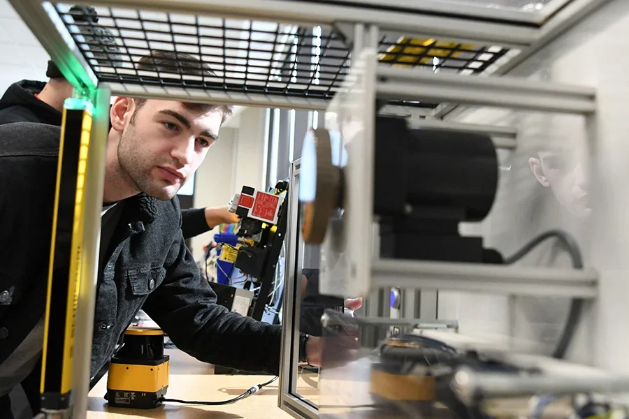 A student works with electronic equipment in a lab.