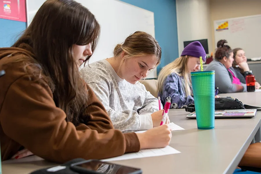 Health students take an exam in a classroom.