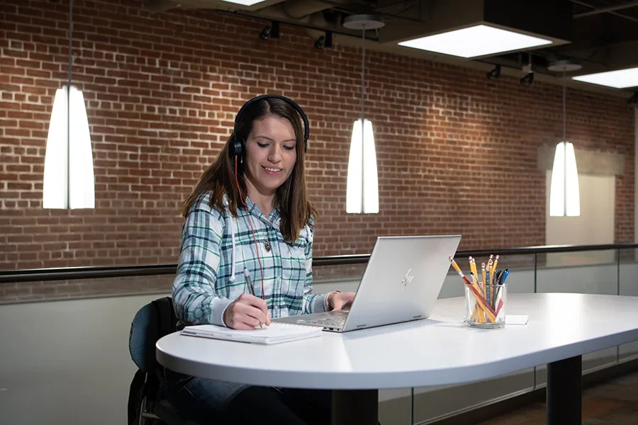 A students works at her computer at a desk.