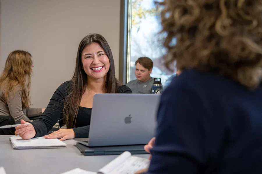 Student smiling at other student in classroom