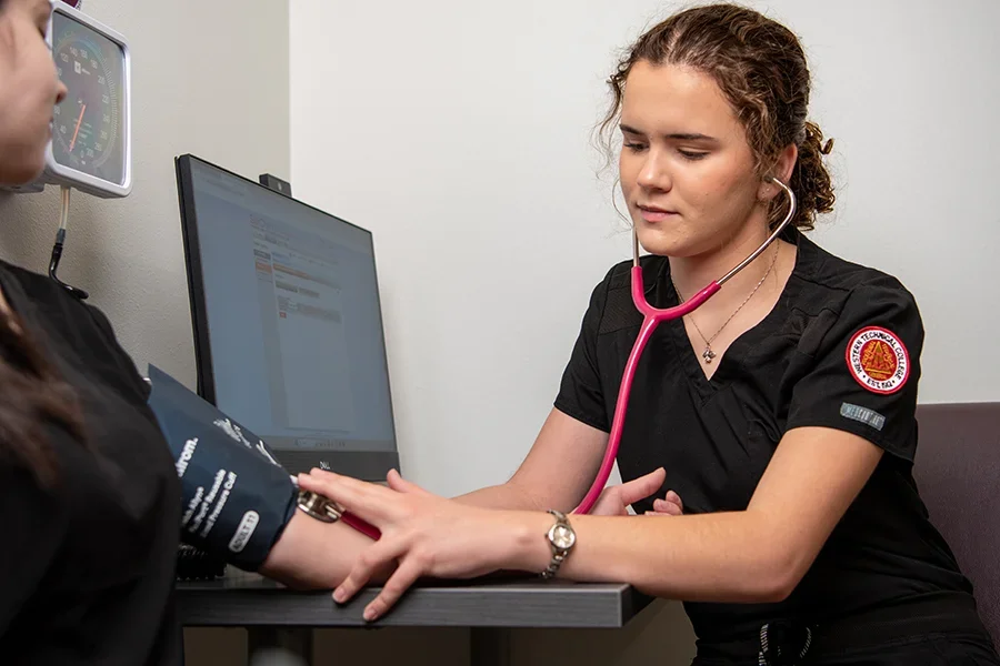 Student taking blood pressure of patient