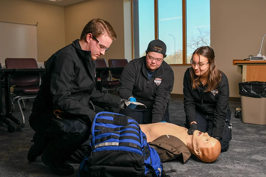 Students practicing on training doll in classroom
