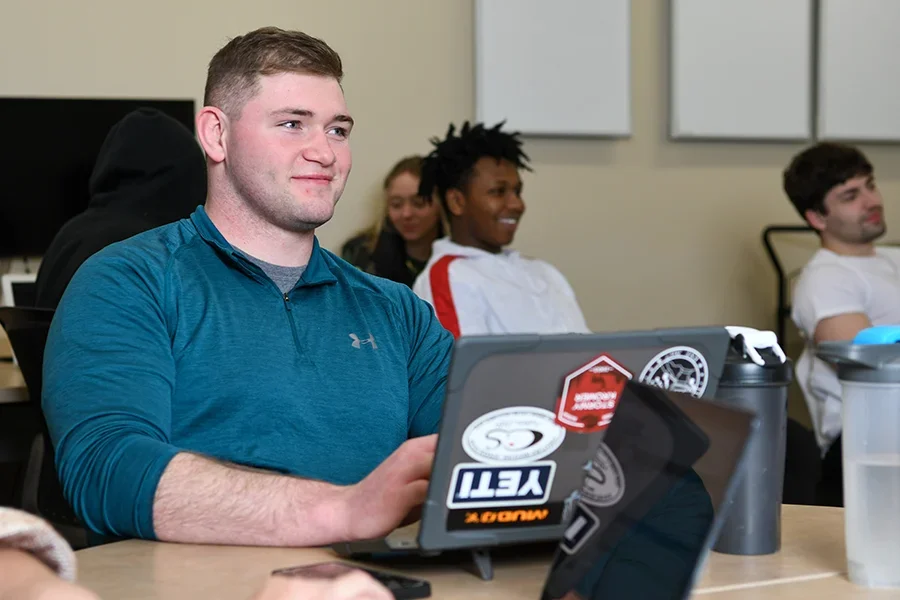 Business student smiling during lecture.