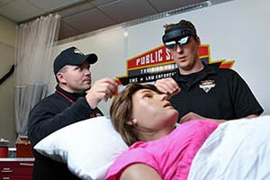 Two students work with manikins as they train for the EMS program.