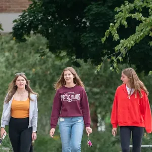 Three female students, walking in the courtyard at Western