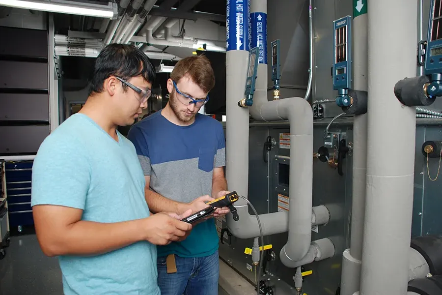 Two student work together to identify issues with an HVAC system.