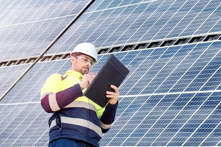 A building professional checks his note aside a large skyscraper.