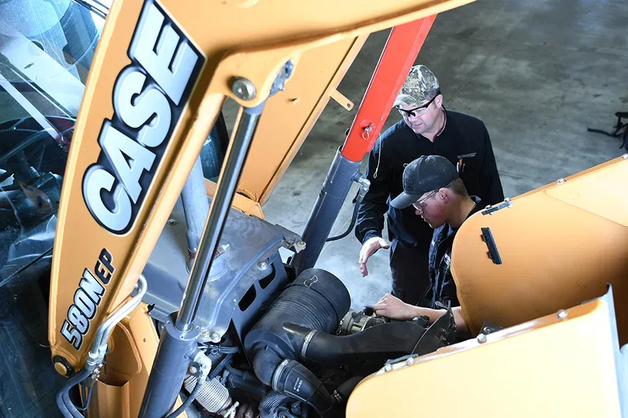 Students work together to repair a large crane.