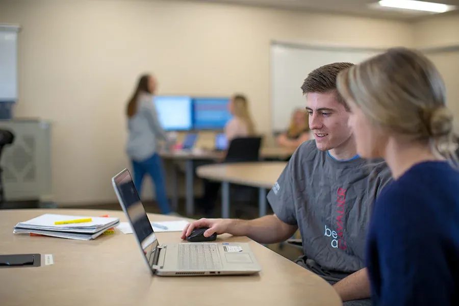 Student work together on a class assignment on a computer.