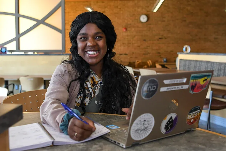 A student with a laptop studies at the Union Market at Western
