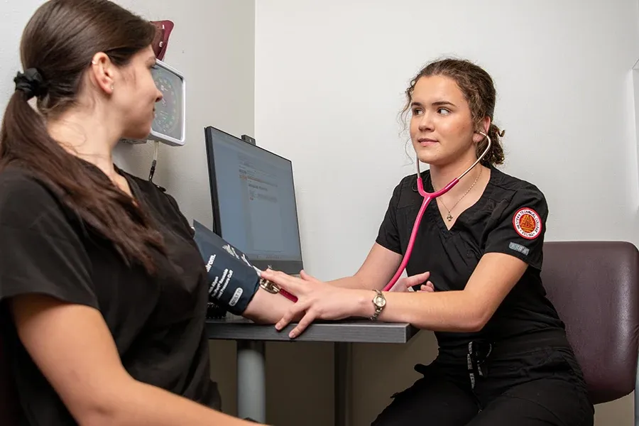 A Clinical Medical Assistant student learns how to take blood pressure