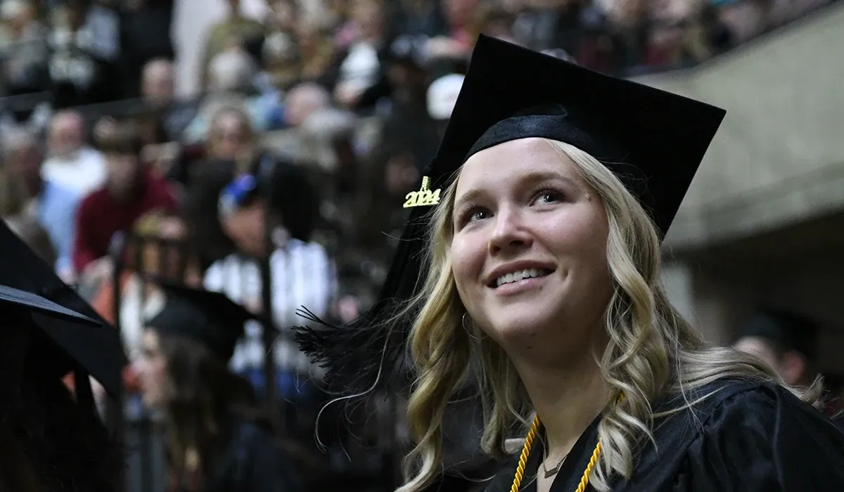 A female Western student in her cap and gown at graduation