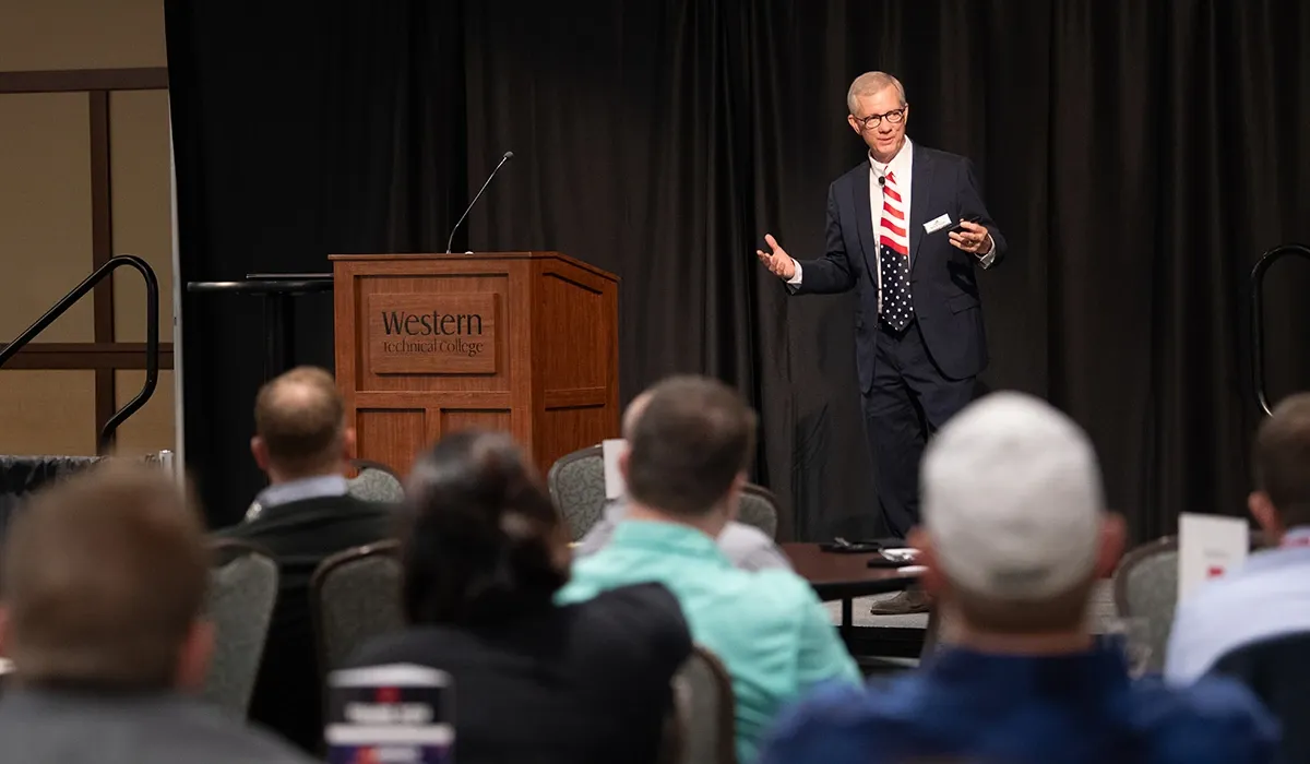 A speaker presents to a room of community members in the Lunda Center