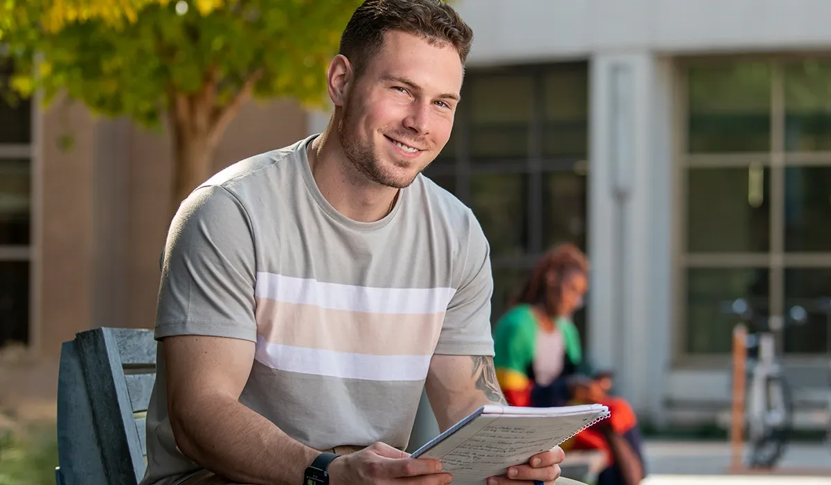 A male Western student, studying outside on campus