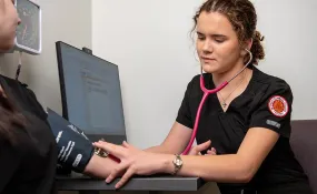 Student taking blood pressure of patient